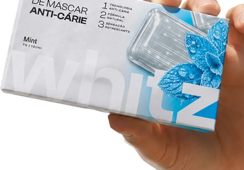 Mão segurando a caixa da goma de mascar anticárie Whitz sabor Mint