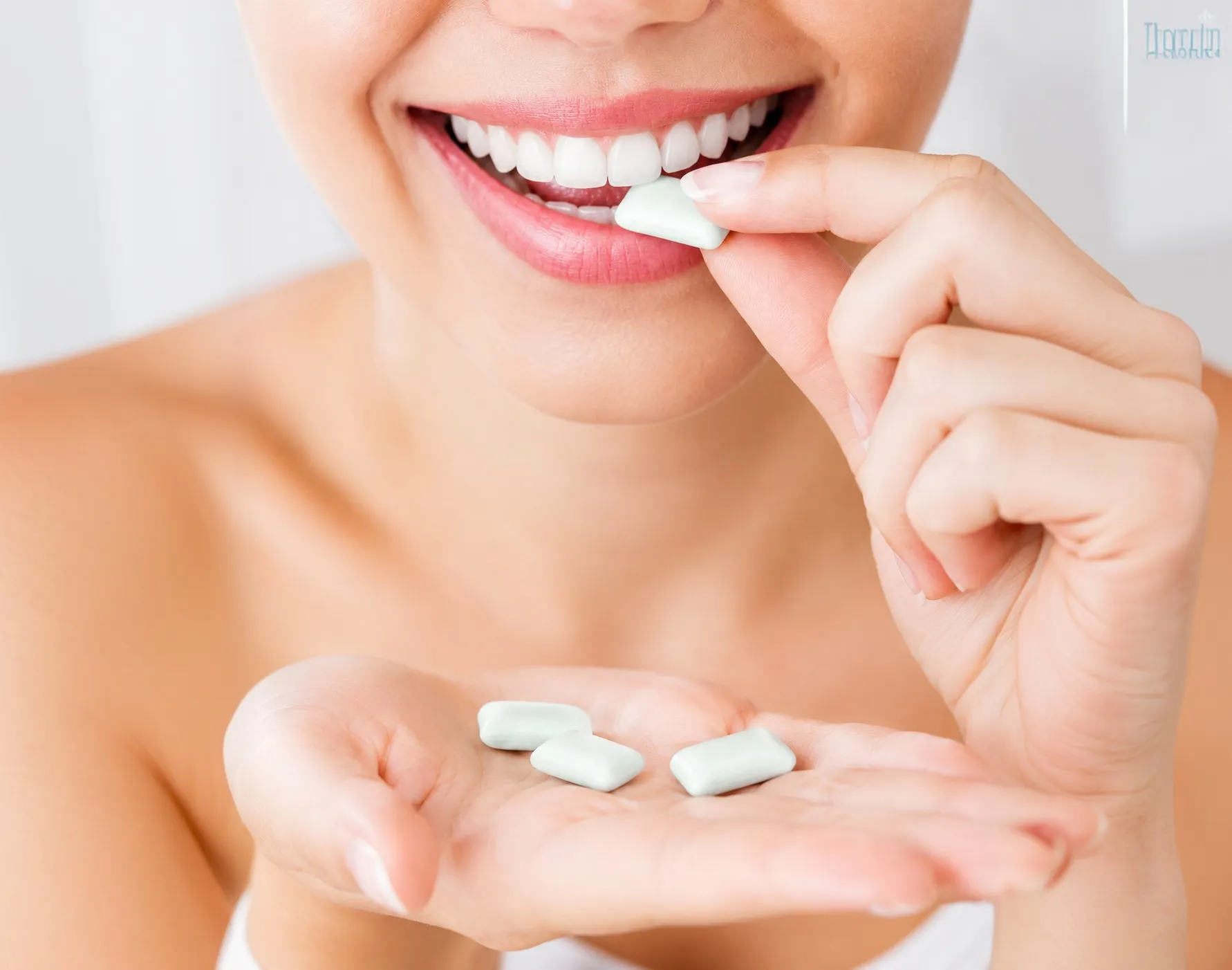 Mulher sorrindo enquanto morde uma goma de mascar Whitz, segurando outras gomas na mão