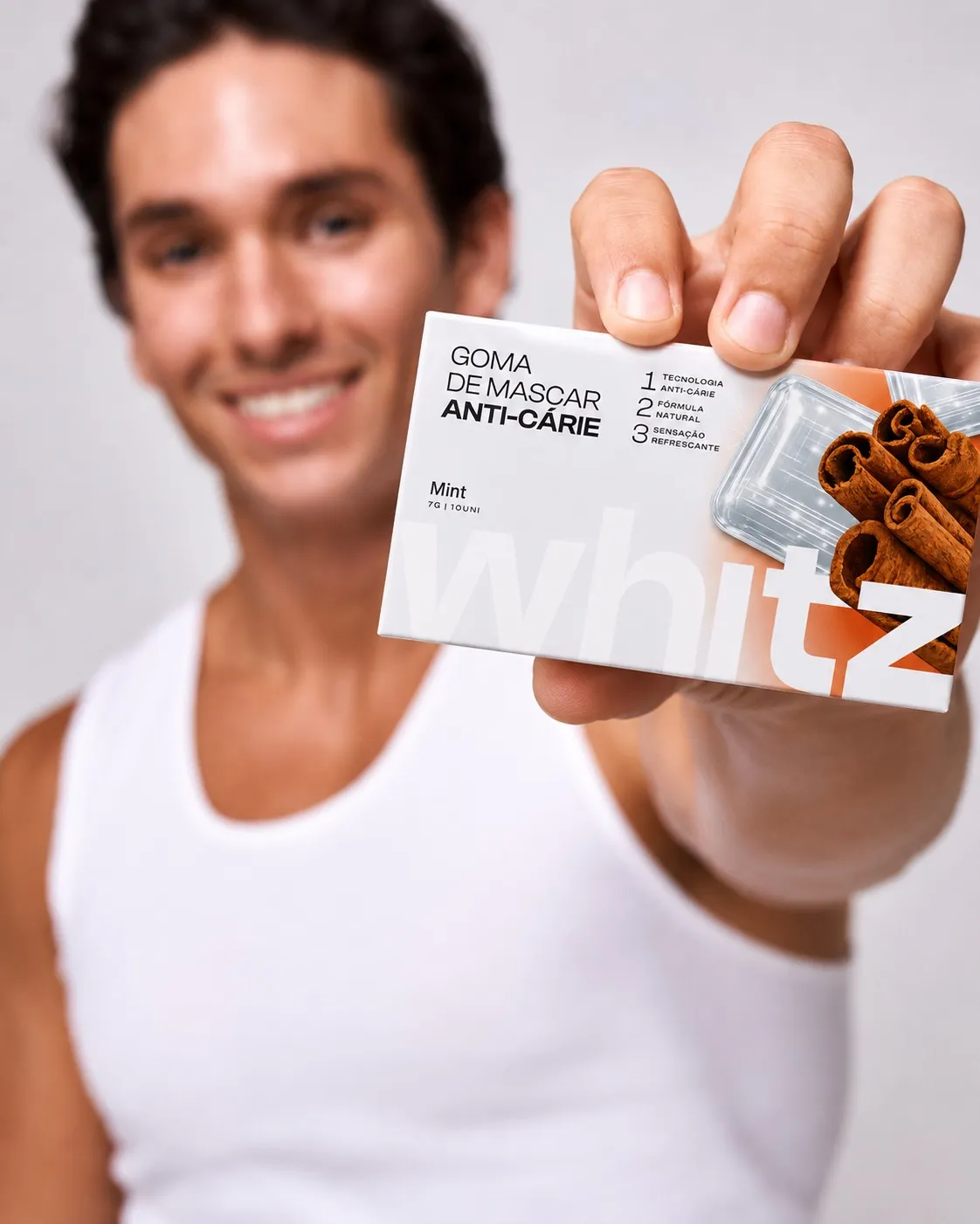 Homem sorrindo mostrando a caixa da goma de mascar Whitz