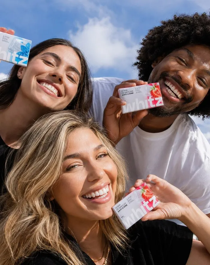 Amigos sorrindo mostrando embalagens de Whitz